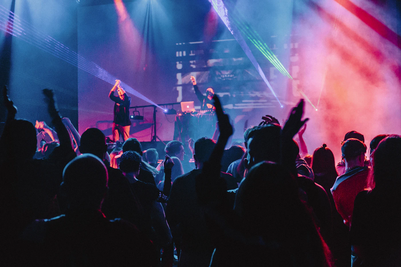 Live musicians performing in silhouette against colorful stage lights
